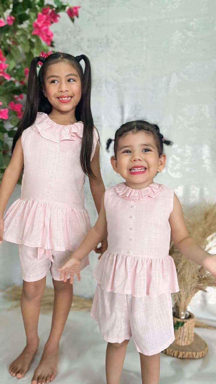 Dos niñas con el Conjunto Amapola, tomadas de la mano