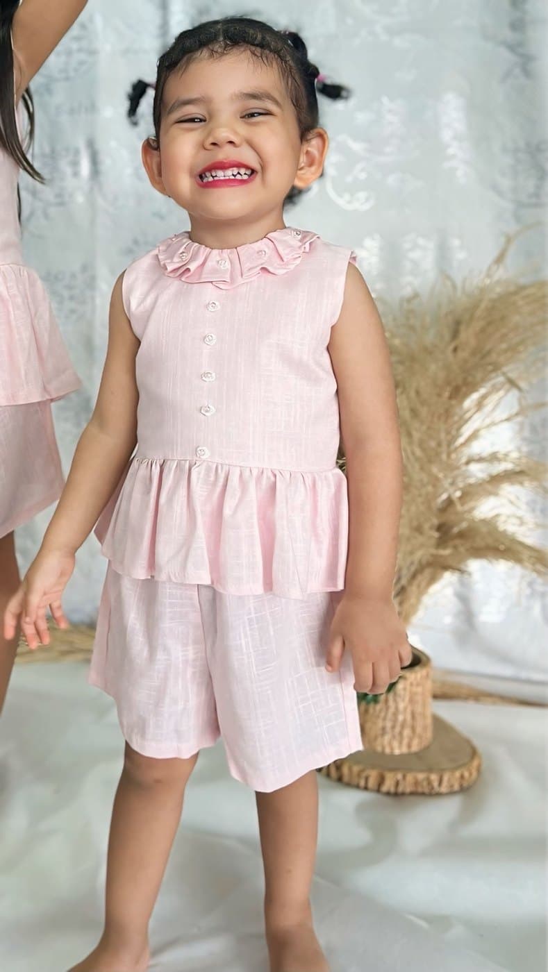 Niña pequeña con el Conjunto Amapola, sonriendo